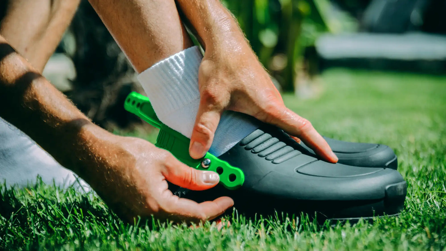 Grüner Kunststoff-Schuhdehner wird verwendet, um einen schwarzen Gummistiefel anzupassen